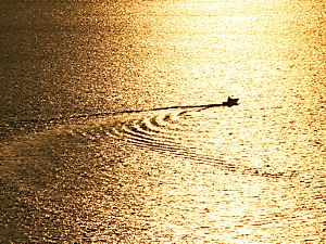 夕日に輝く海面と漁船のシルエット