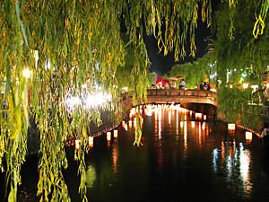 大谿川をゆっくりと流れる竹灯籠と城崎の夜景